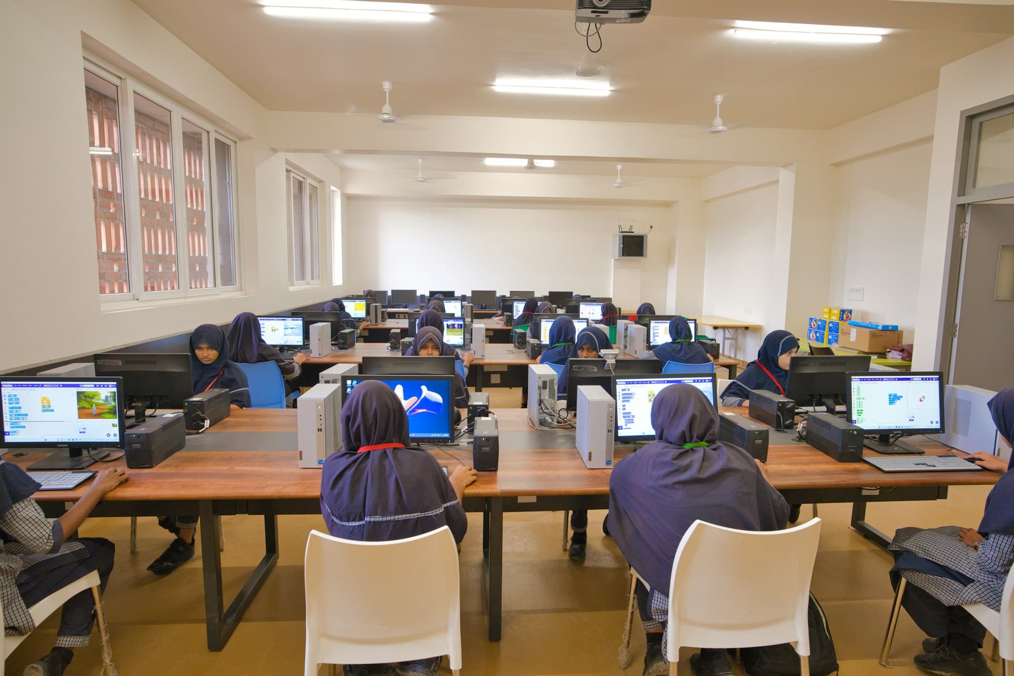 Students learning practical computer skills in a classroom